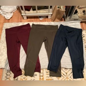 Three pairs of Lululemon crop style and burgundy, olive and blue gently worn